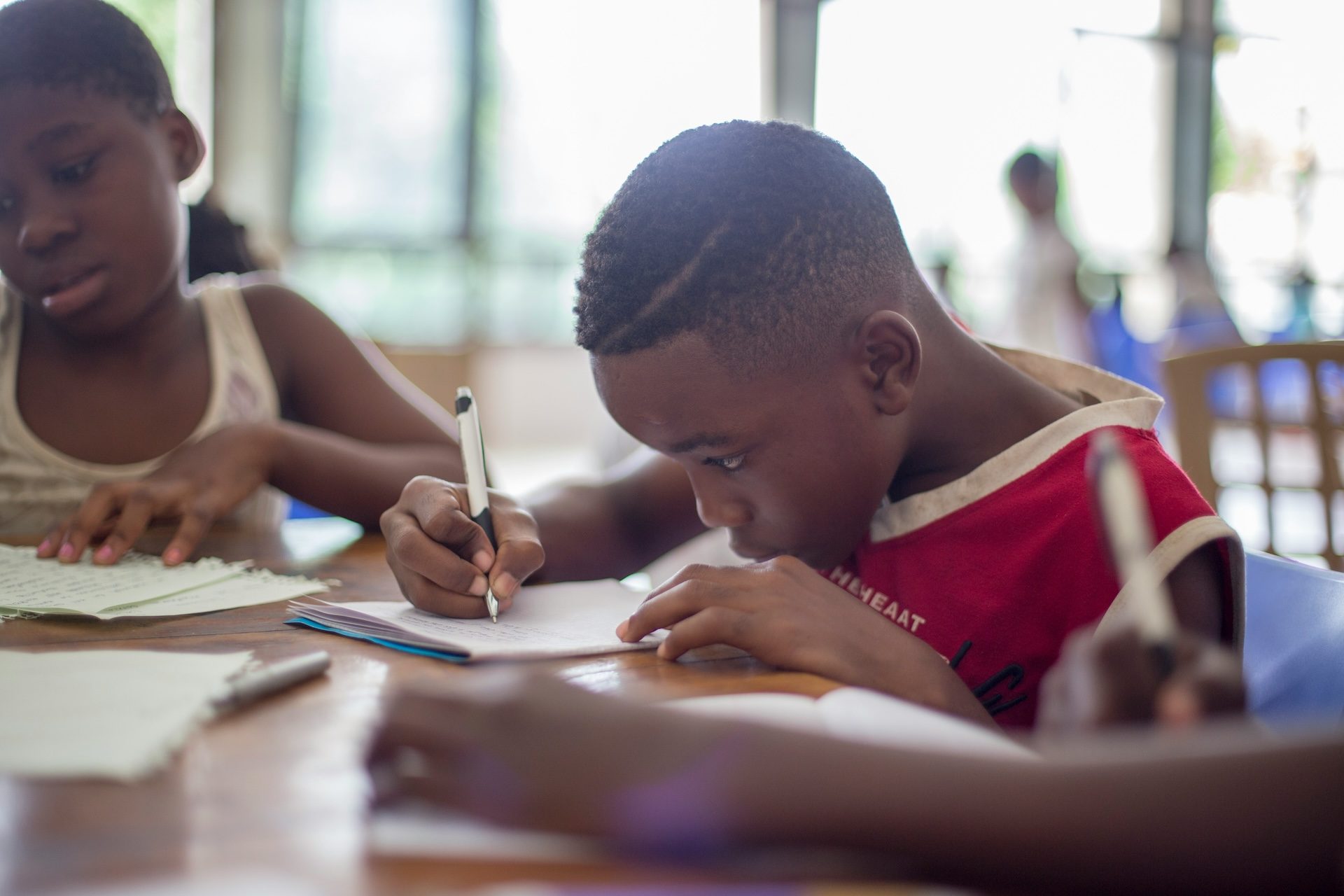 child writing on notepad